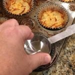 Pressing down baked hash browns in foil baking cup