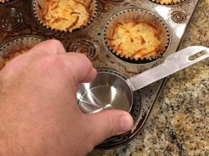 Pressing down baked hash browns in foil baking cup