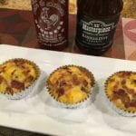 Three barbecue breakfast cupcakes on serving platter with sriracha and barbecue sauce