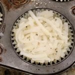 Shredded potatoes placed in foil baking cup