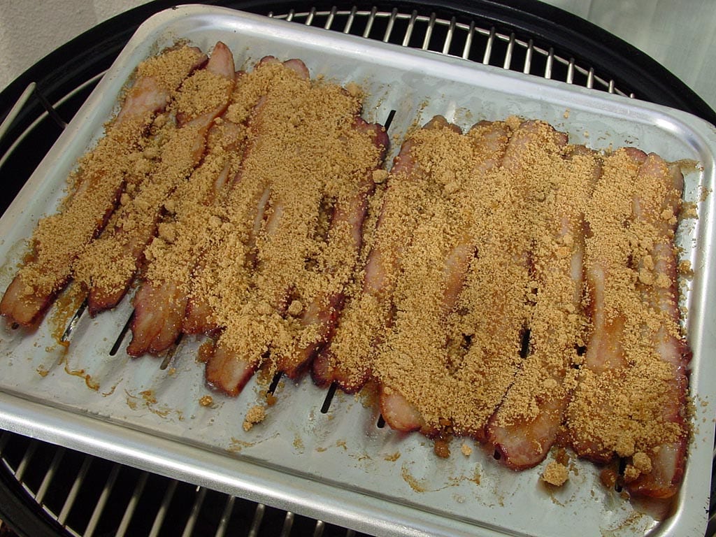 Applying brown sugar mixture to bacon halfway through cooking