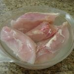 Chicken breasts in glass bowl