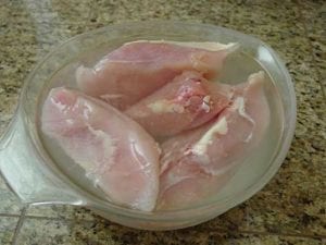 Chicken breasts in glass bowl
