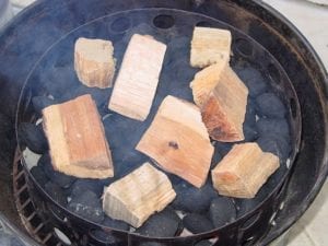 Smoke wood and unlit charcoal over a bed of hot coals