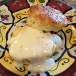 Close-up of a split black pepper biscuit with country gravy