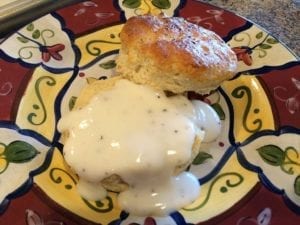 Close-up of a split black pepper biscuit with country gravy