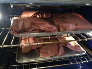Ribs wrapped in pink butcher paper in 275F oven