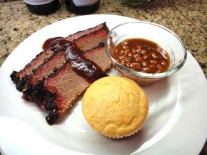 Sliced brisket with sauce, beans & corn muffin