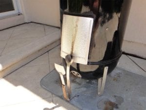 Upside down access door propped open with tongs