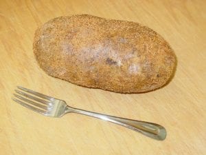 Jumbo baking potato covered with butter and rub