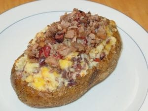 Twice-baked potato topped with butter, cheese, and more brisket