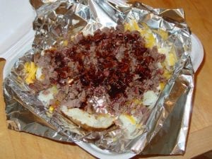 Smashed potato with cheese, sour cream, brisket, and barbecue sauce