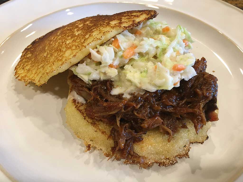Pulled pork with coleslaw on cornmeal hoecakes