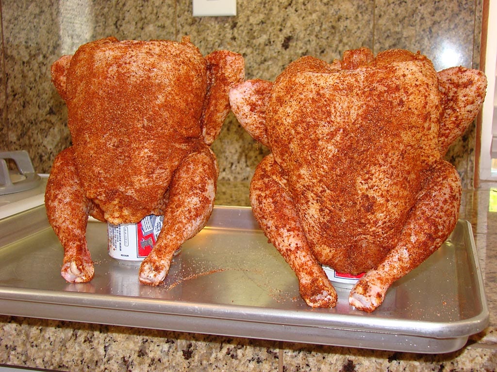 Two chickens rubbed and sitting on beer cans