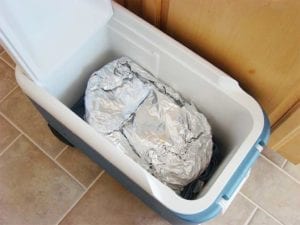 Foiled brisket resting in empty cooler