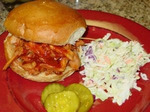 Pulled chicken sandwich with cole slaw and pickles