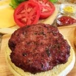 Close-up of bacon/beef burger on a bun with condiments