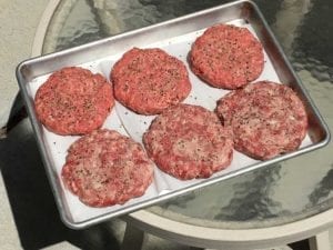 Seasoned patties ready for the smoker