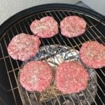 Uncooked patties on the top cooking grate