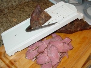 Slicing cold pastrami using a mandolin slicer