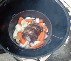 Roast surrounded by vegetables, herbs and seasonings