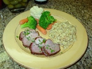 Lamb with roasted garlic jus, rice pilaf, and vegetables
