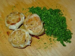 Roasted garlic heads and minced parsley leaves