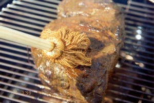 Basting the meat with a string mop