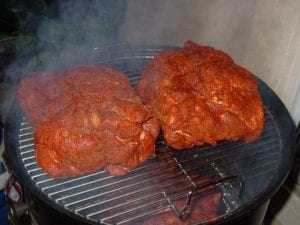 Pork butts go into the cooker