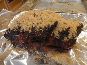 Applying brown sugar to pork butt