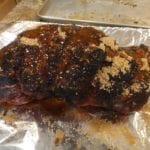 Sprinkling marinade on pork butt