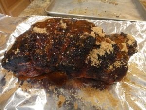 Sprinkling marinade on pork butt
