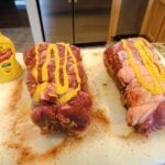 Applying mustard to pork butts