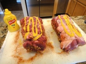 Applying mustard to pork butts