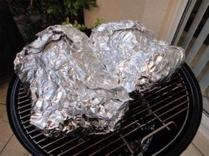 Foiled pork butts go back into the WSM for at least 2 more hours.
