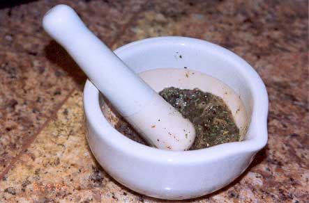 Mortar and pestle containing garlic and herb paste