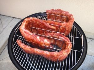 Rubbed spareribs in a rib rack in the WSM