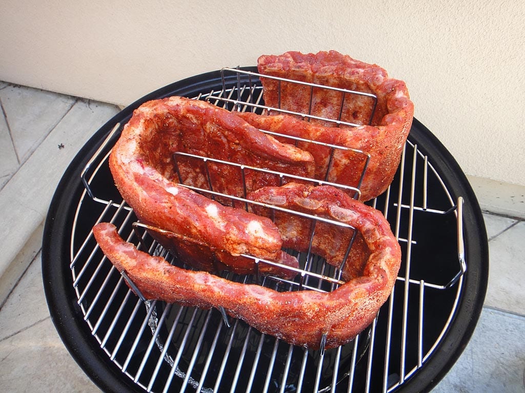 Rubbed spareribs in a rib rack in the WSM