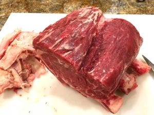 Trimmed standing rib roast with removed fat on the side