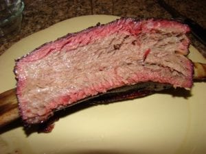A single bone-in short rib fills a large dinner plate