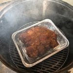 Smaller pork butt on bottom cooking grate