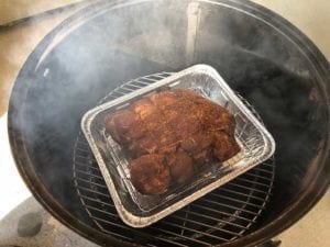 Smaller pork butt on bottom cooking grate