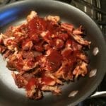 Heating rib meat and BBQ sauce in skillet