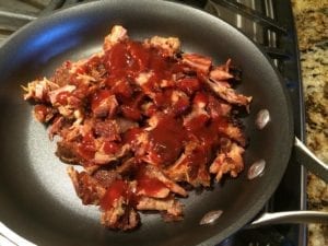 Heating rib meat and BBQ sauce in skillet