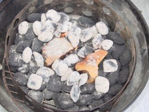 Thirty hot coals added to unlit briquettes and smoke wood
