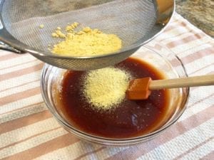 Sifting dry mustard into sauce