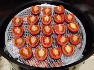 Tomatoes on pizza screen over bottom cooking grate