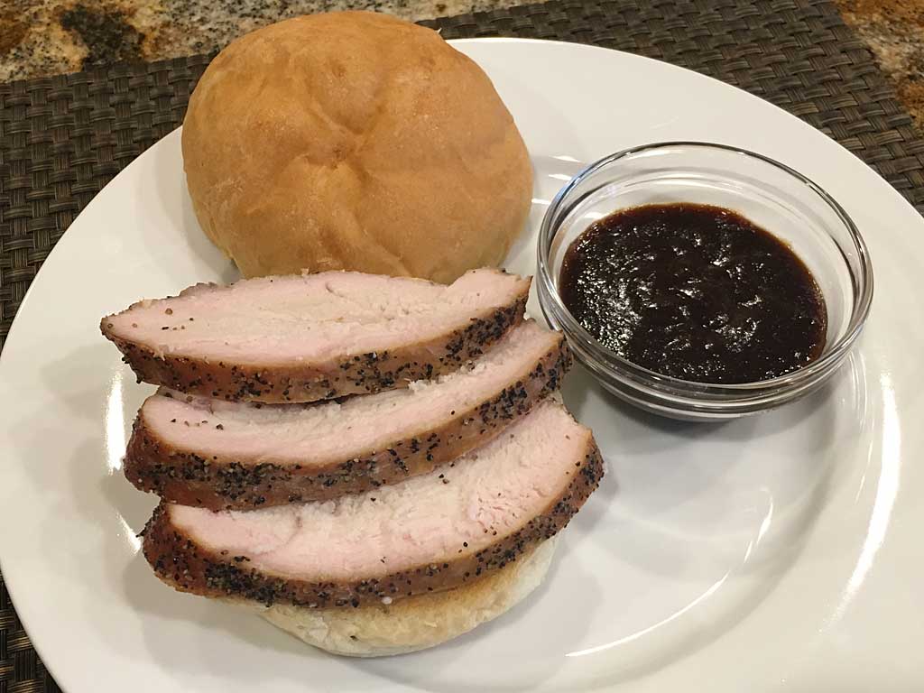 Sliced turkey breast sandwich with BBQ sauce on the side