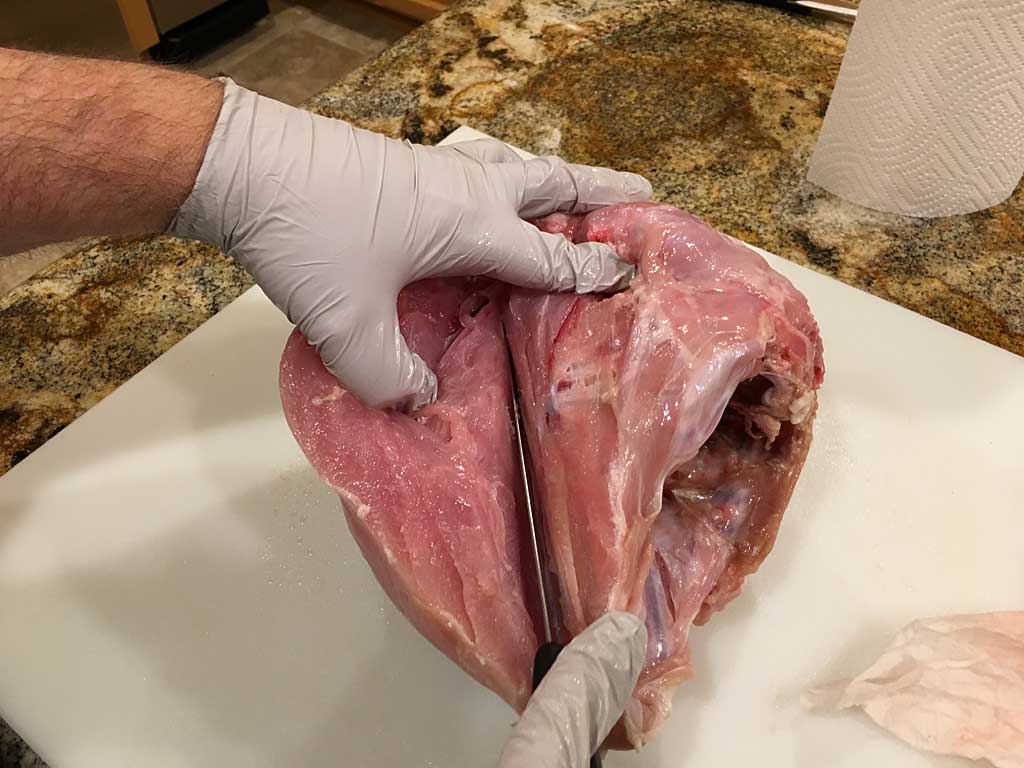 Removing breast meat from one side of rib cage