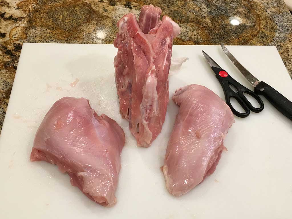 Two boneless, skinless turkey breasts with rib cage in the center